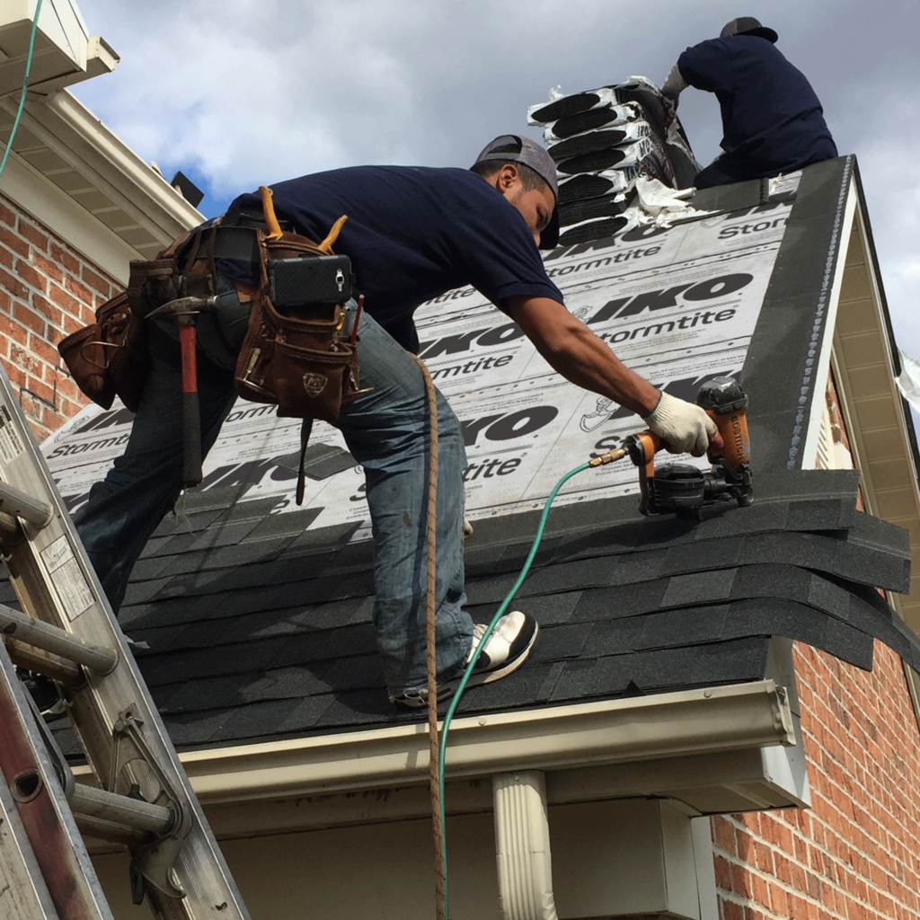 Roofing contractor installing new shingles during a roof replacement in Edmonton, Alberta
